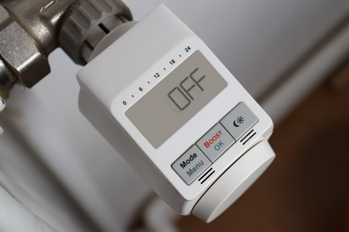 Thermostat digital fixé sur un radiateur, écran OFF, boutons de contrôle visibles