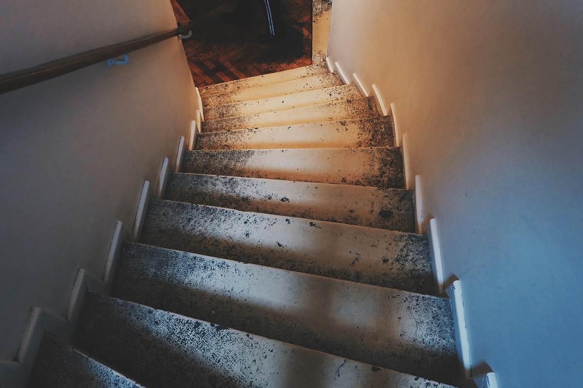 Escalier étroit avec main courante le long du mur