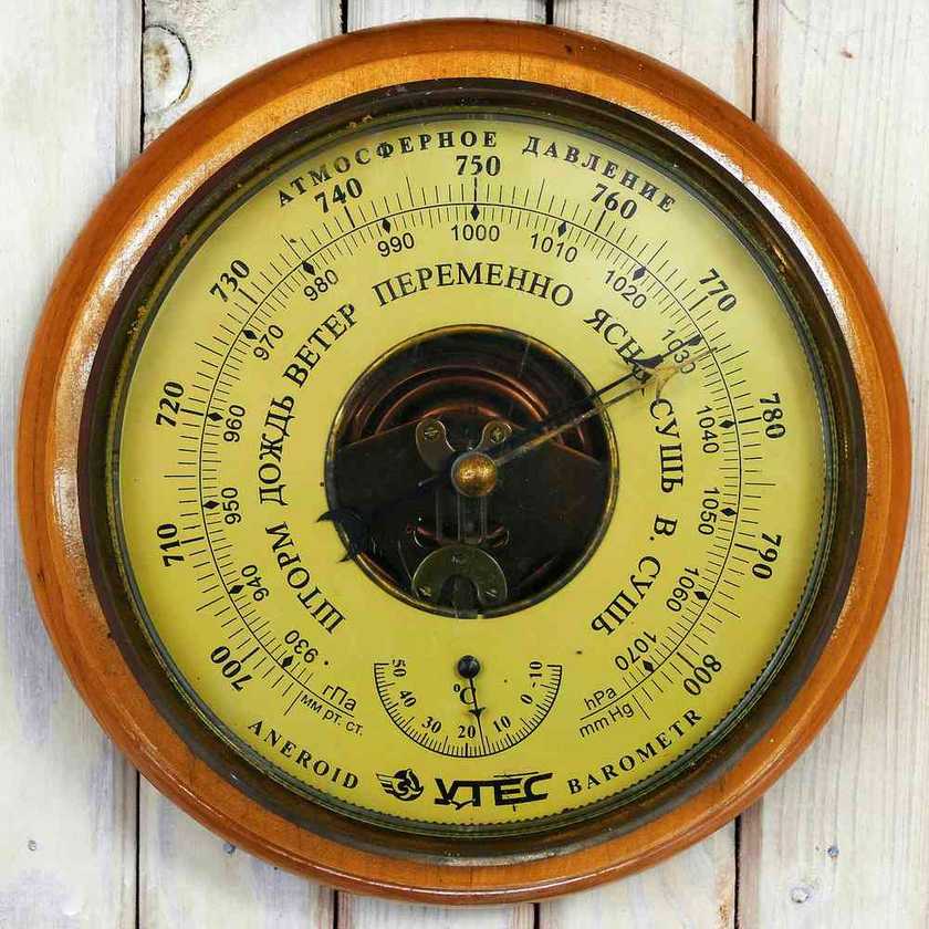 Baromètre analogique en bois avec affichage en russe et aiguille indiquant 750
