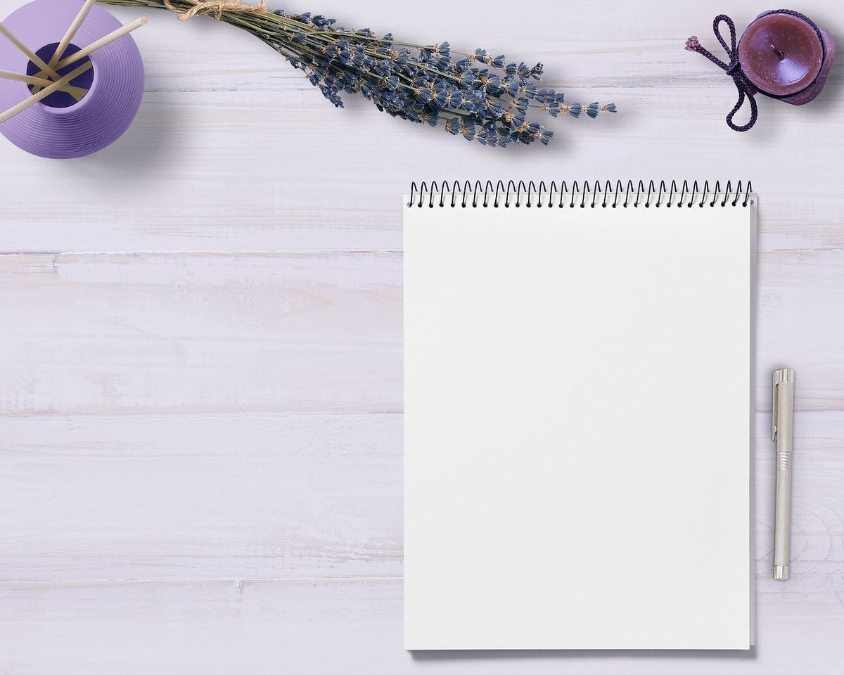 Carnet vierge stylo lavande et vase violet sur planche